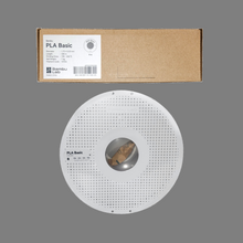 Load image into Gallery viewer, Packaging and spool of BambuLabs PLA 3D printer filament in gray color, displayed on a flat surface.